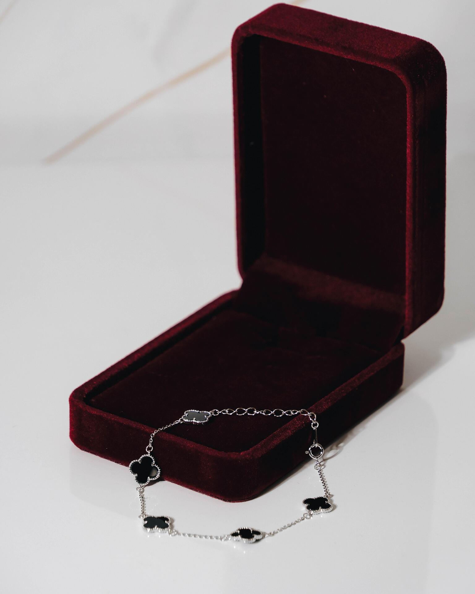 Silver bracelet with black clovers