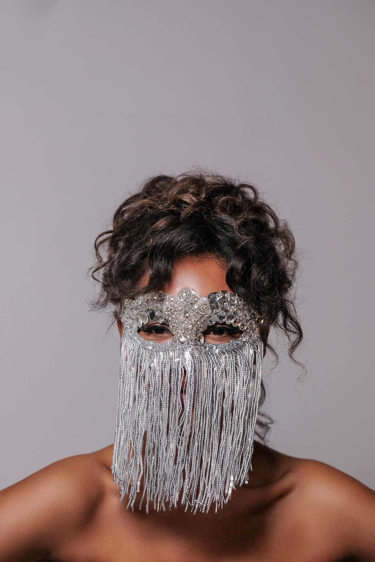 Silver mask with stones and hanging threads: Beyond