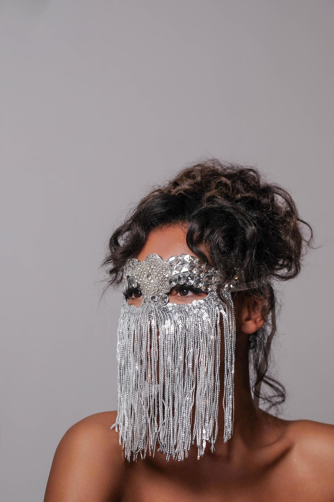 Silver mask with stones and hanging threads: Beyond