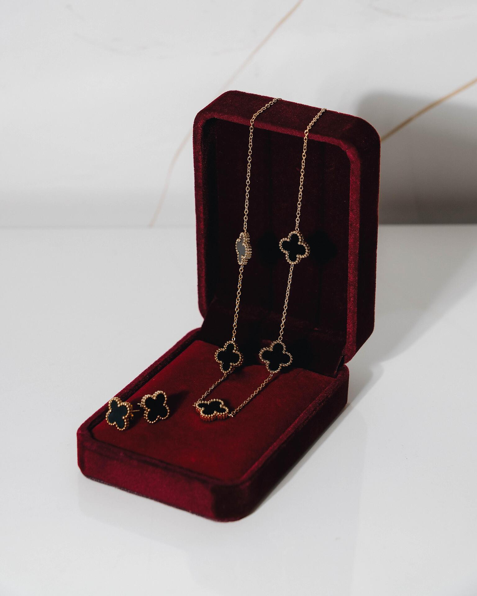Gold-tone clover necklace and earrings set in black