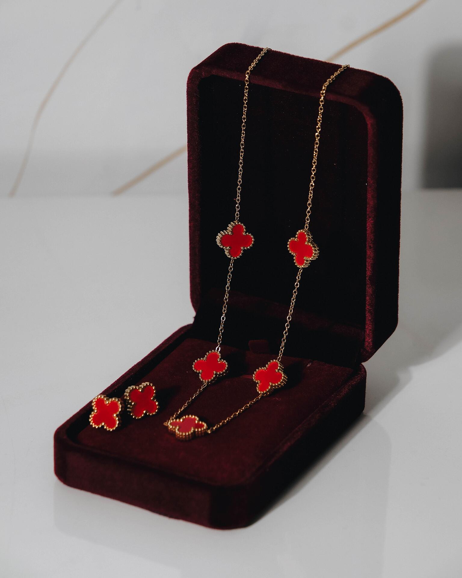 Gold-tone necklace and earrings set with red clovers