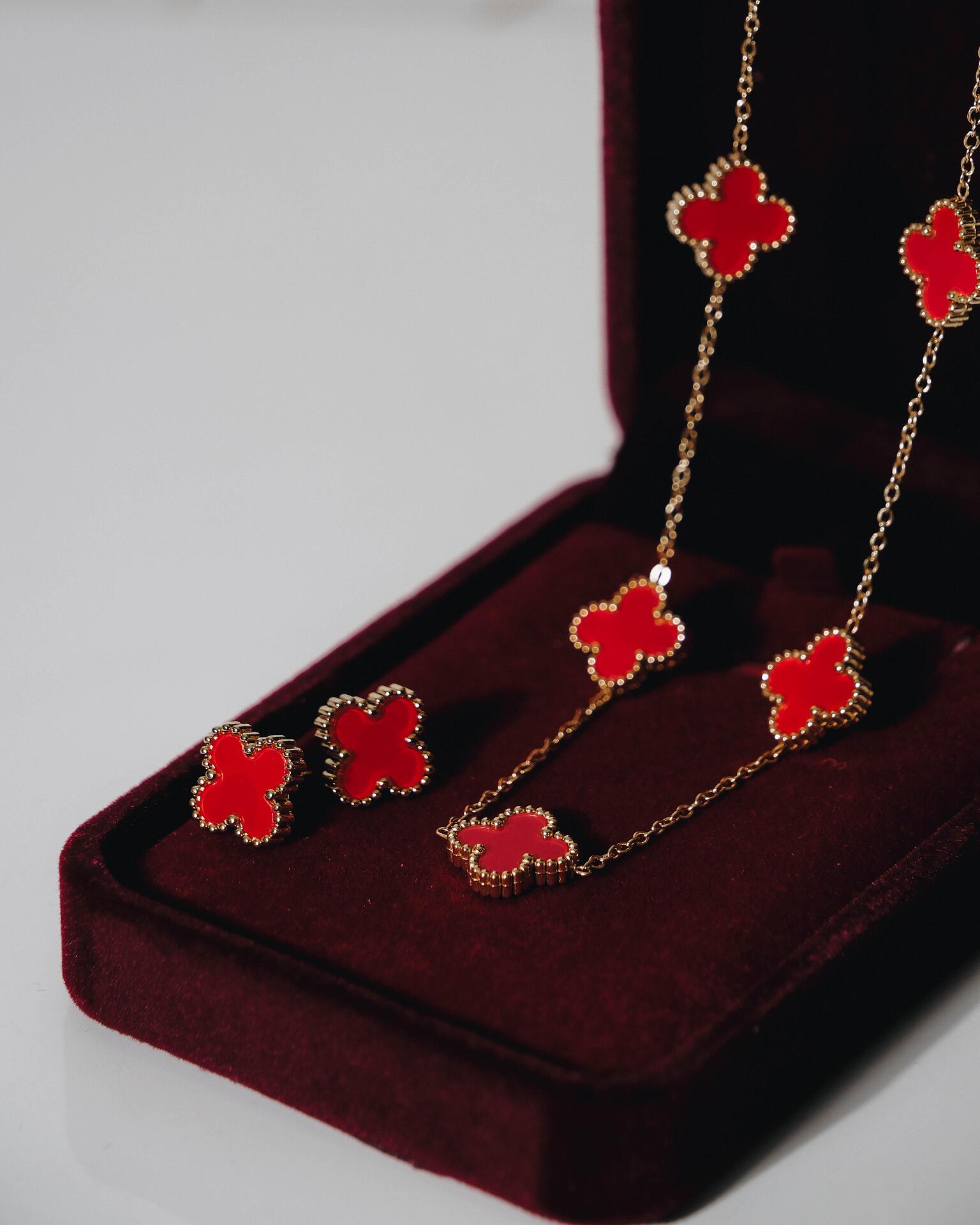 Gold-tone necklace and earrings set with red clovers