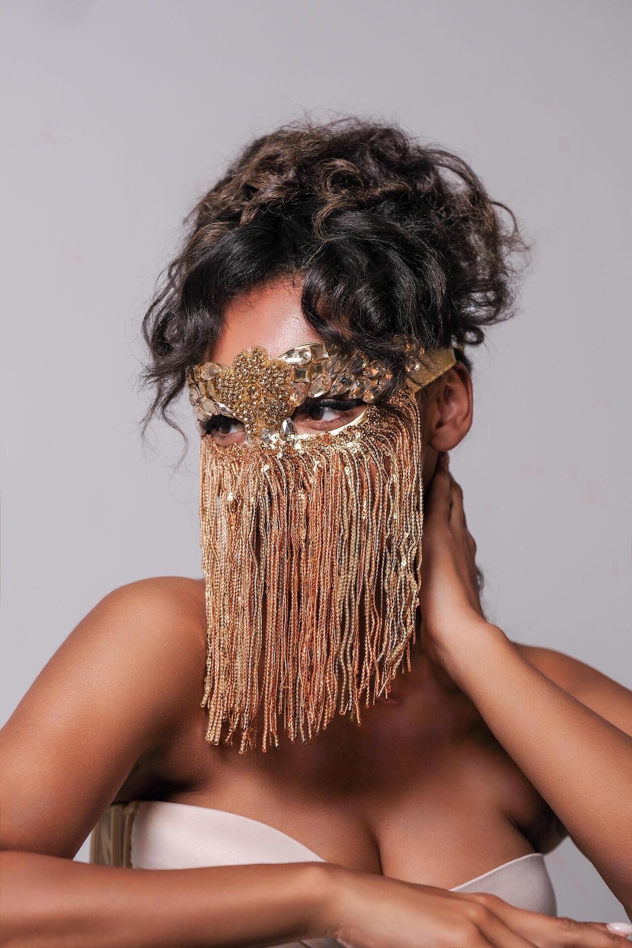 Golden mask with stones and hanging threads: Beyond